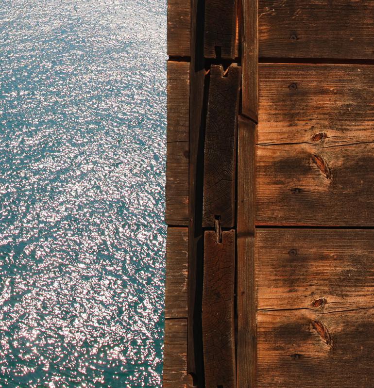 Mare scintillante e legno, contrasto tra natura e struttura.